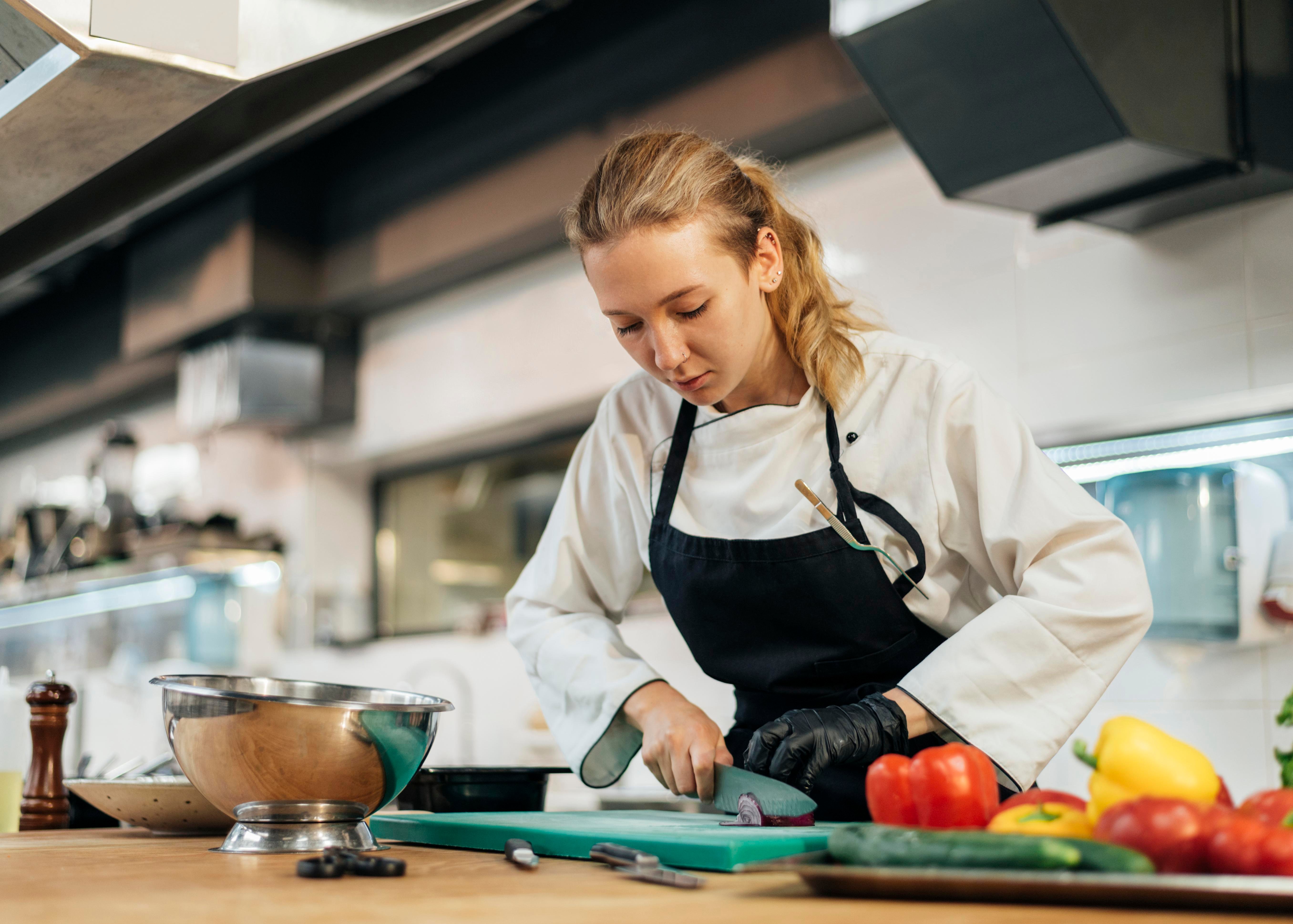 chef-feminina-cortando-vegetais-na-cozinha