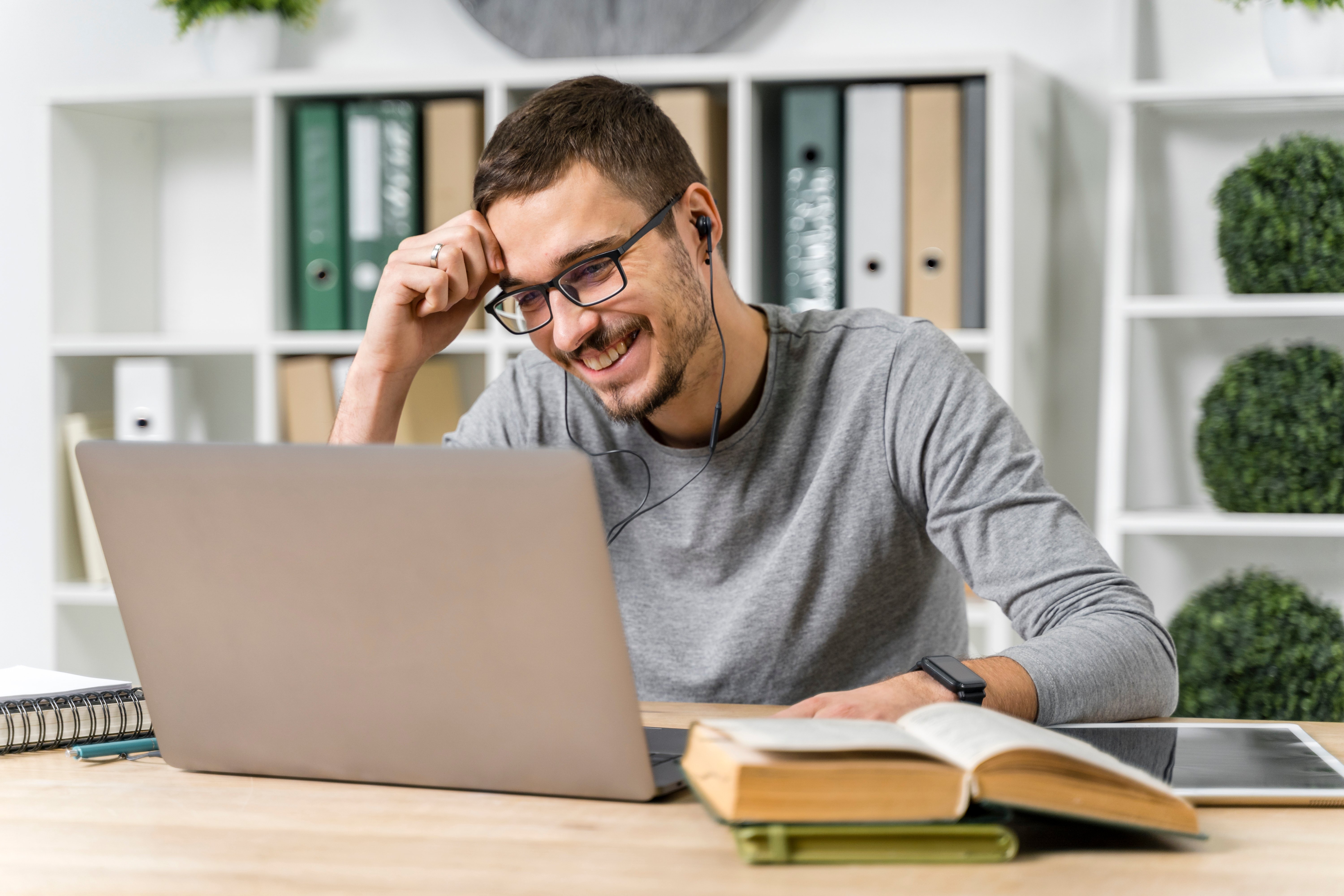 medium-shot-smiley-guy-studying-with-his-laptop