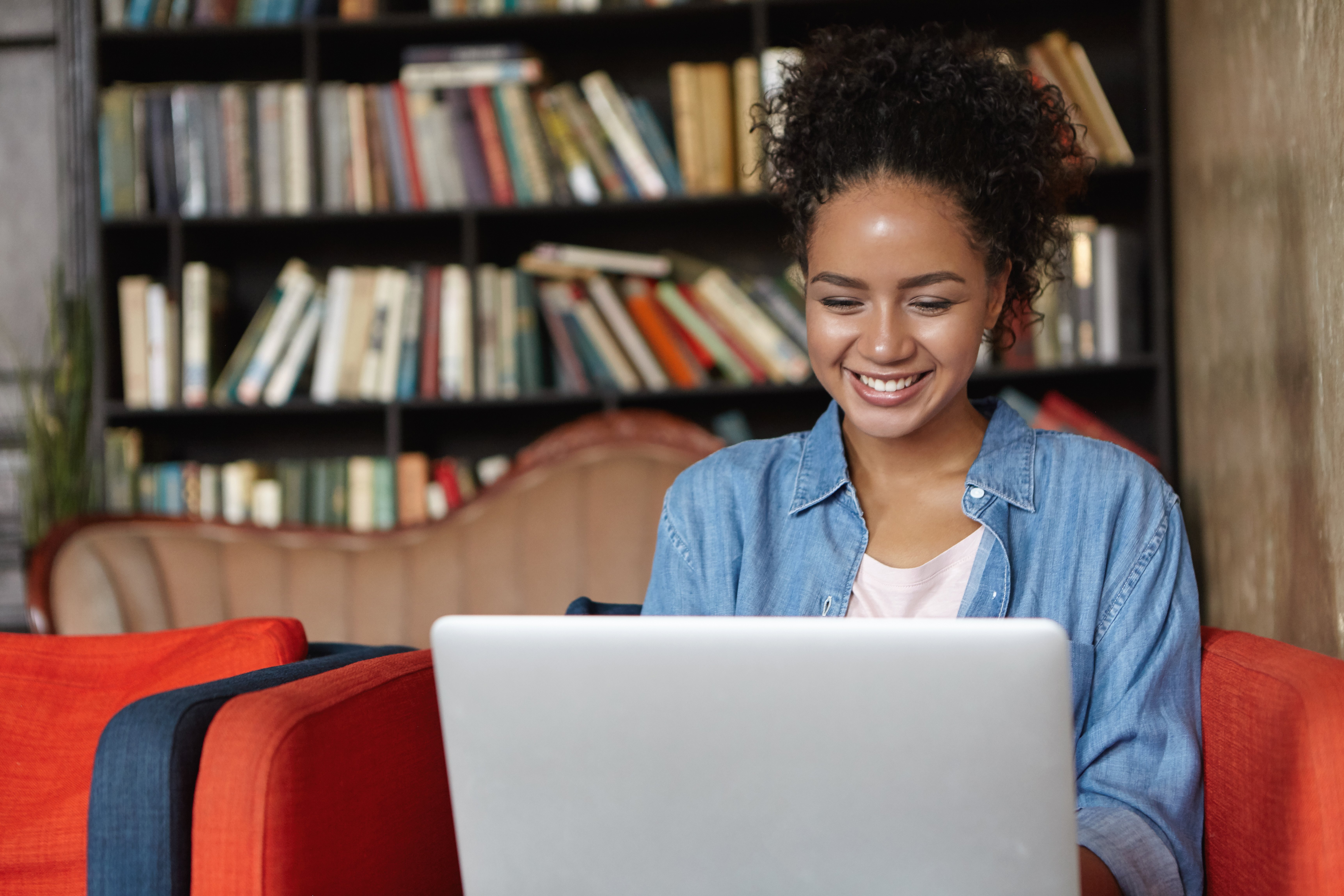 mulher-sentada-em-uma-biblioteca-com-seu-laptop-1