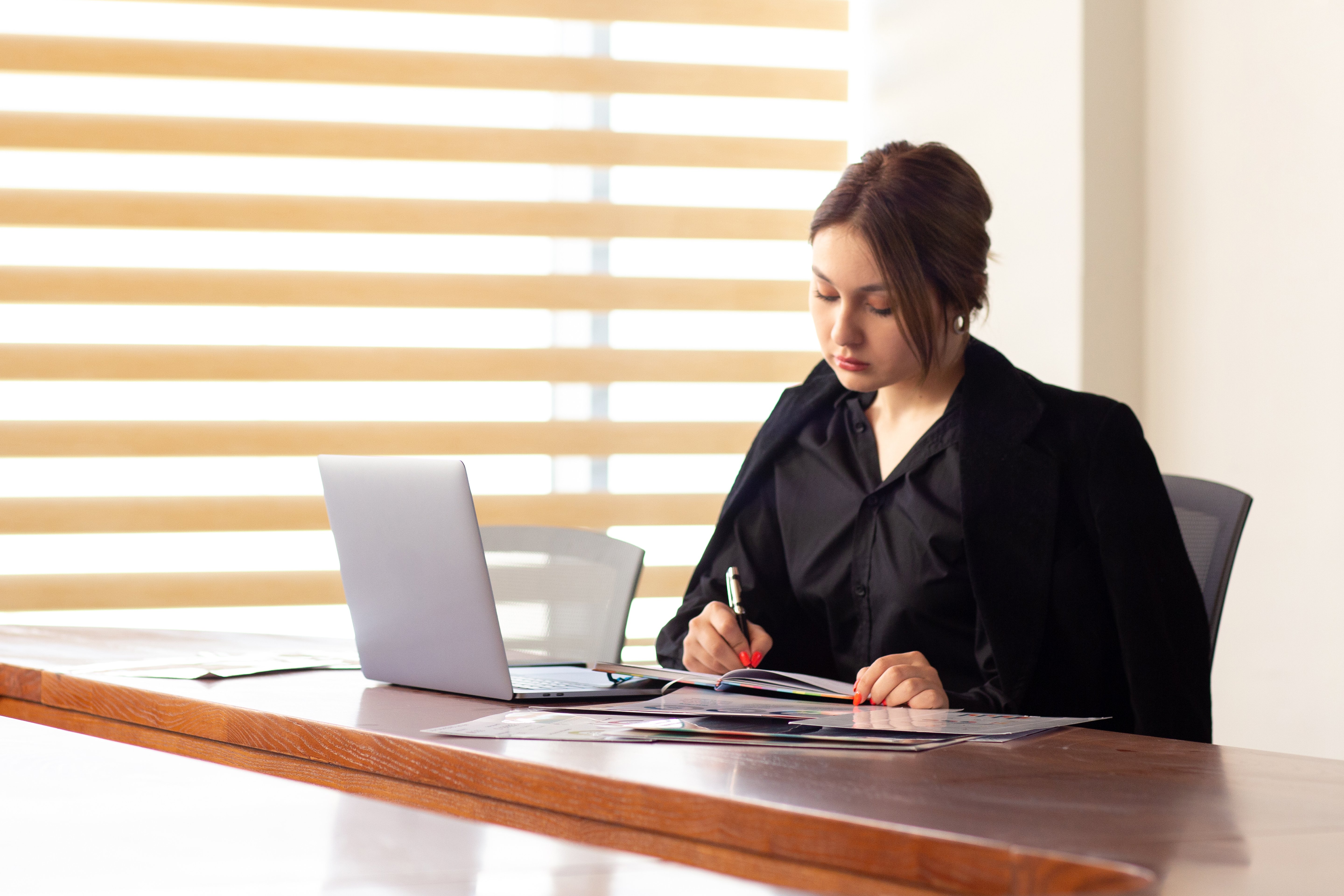 uma-vista-frontal-jovem-empresaria-linda-camisa-preta-jaqueta-preta-usando-seu-laptop-prata-escrita-lendo-trabalhando-dentro-de-seu-escritorio-trabalho-edificio-de-trabalho