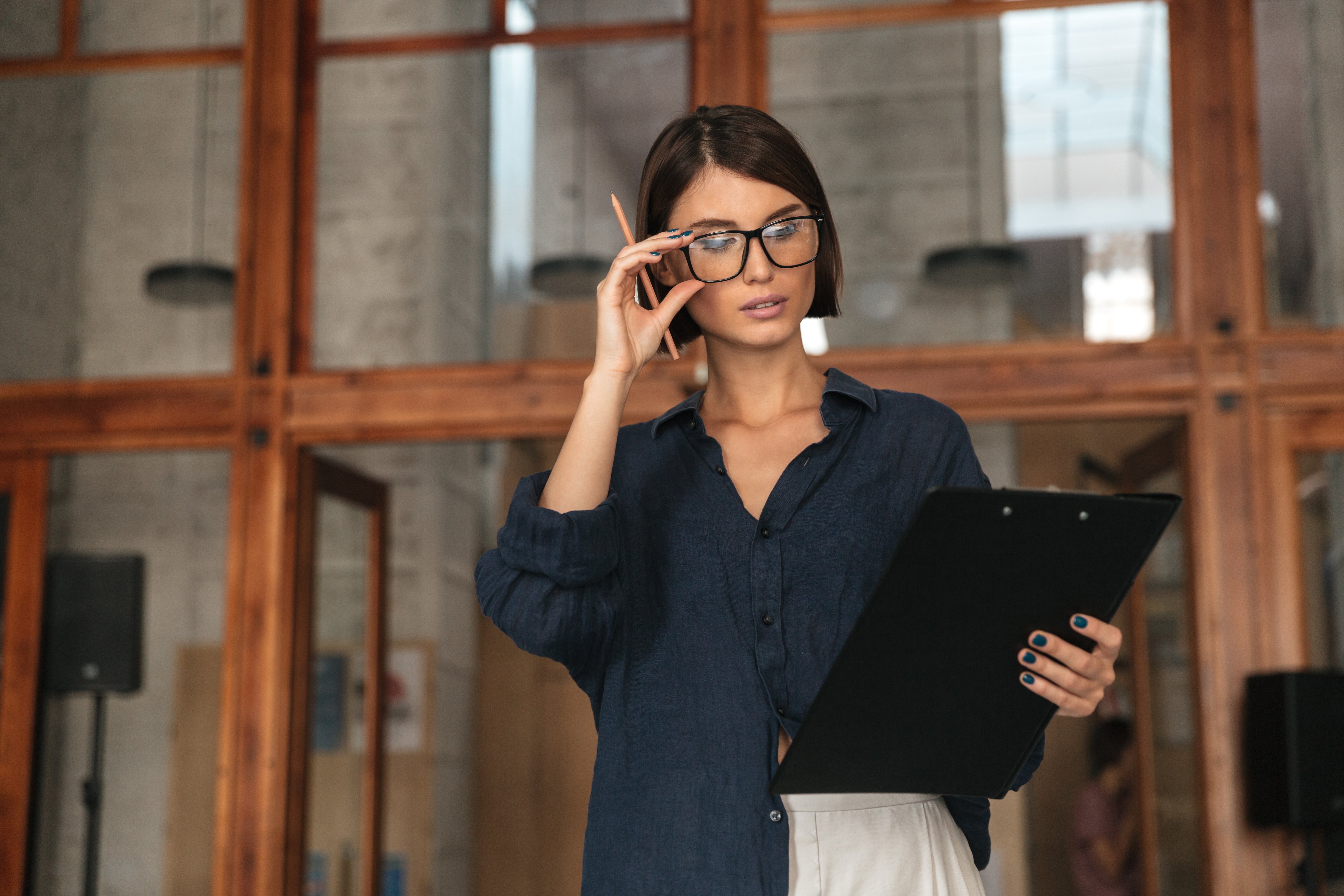 vista-lateral-da-mulher-de-negocios-serios-em-oculos-no-escritorio-de-trabalho-co-sobre-a-porta-de-vidro